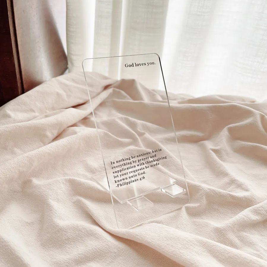 Acrylic phone stand printed with 'God Loves You' and Philippians 4:6-7 Bible verse