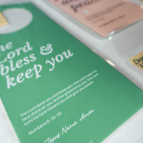 Close-up view of a green Christian door hanger featuring the Bible verse 'The Lord bless and keep you' from Numbers 6:24-26, highlighting faith and blessings.