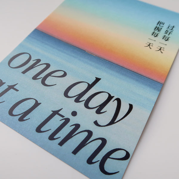 A motivational greeting card featuring the message "One Day at a Time," designed to inspire positivity, small steps, and daily encouragement.