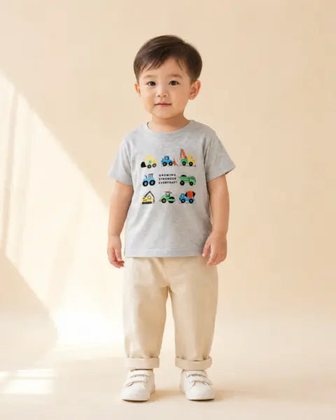 Child wearing a grey Growing Stronger Everyday Christian kids T-shirt with construction vehicles