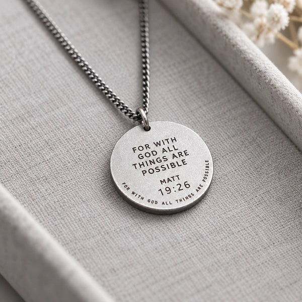Gunmetal round necklace with Matthew 19:26 verse displayed on a grey jewellery tray
