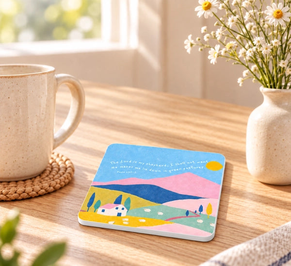 Psalm 23 He makes me lie down in green pastures Christian coaster in a bright sunlit home setting