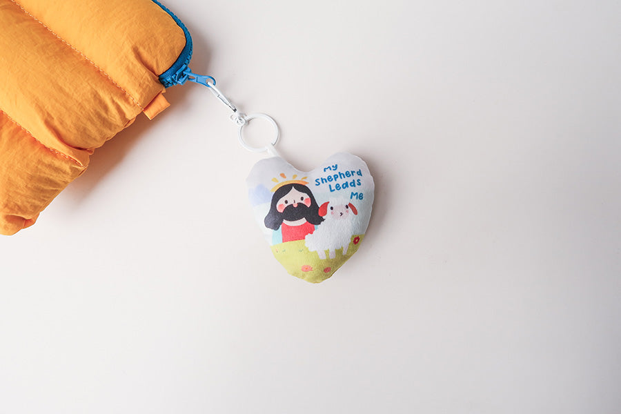 Soft and cute heart plush keychain with Jesus and a sheep illustration, offering comfort and inspiration with 'My Shepherd Leads Me' message.