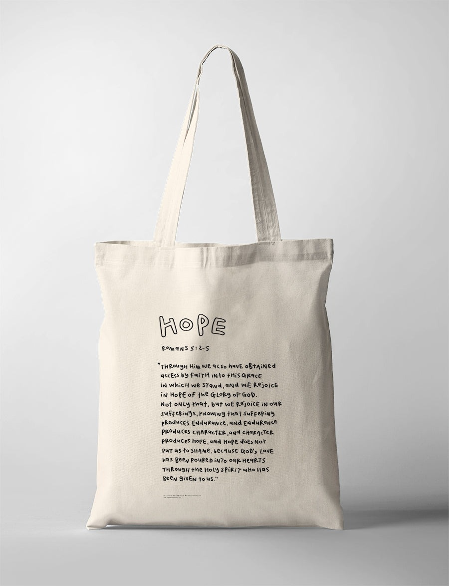Hope Bible verse tote bag featuring Romans 5:2-5 in a handwritten typography design on a natural canvas tote.