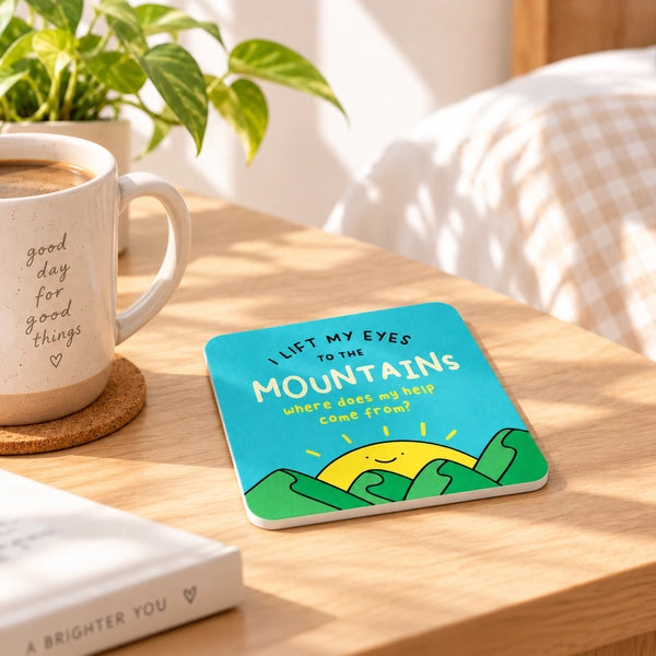 I Lift My Eyes to the Mountains Christian coaster styled on a warm sunlit table