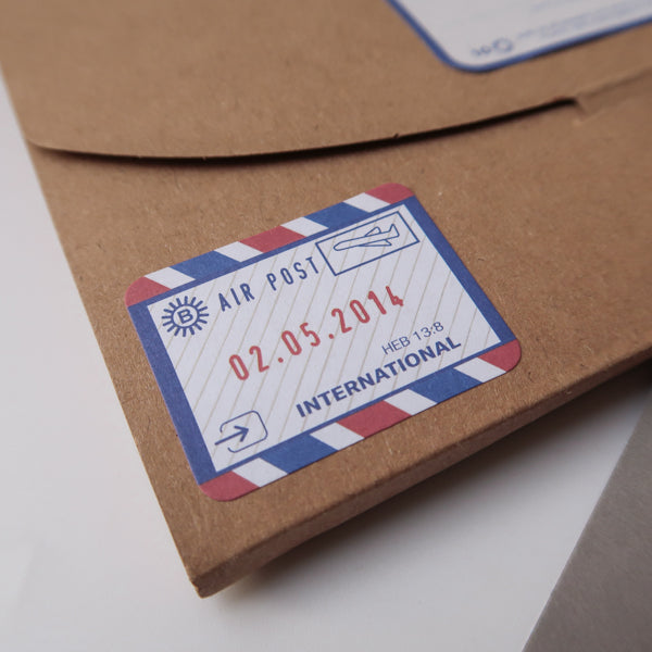 A close-up of a brown envelope featuring a vintage-style air post label dated 02.05.2014, marked 'International,' adding a nostalgic touch to the package.