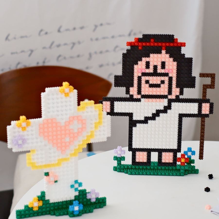 Micro building sets featuring a joyful Jesus figure with a shepherd’s staff and a cross adorned with a heart and flowers, symbolizing hope, light, and simple happiness.