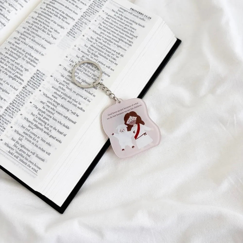 Christian acrylic keychain featuring Jesus and a sheep beside an open Bible, with a reminder of God’s unconditional love