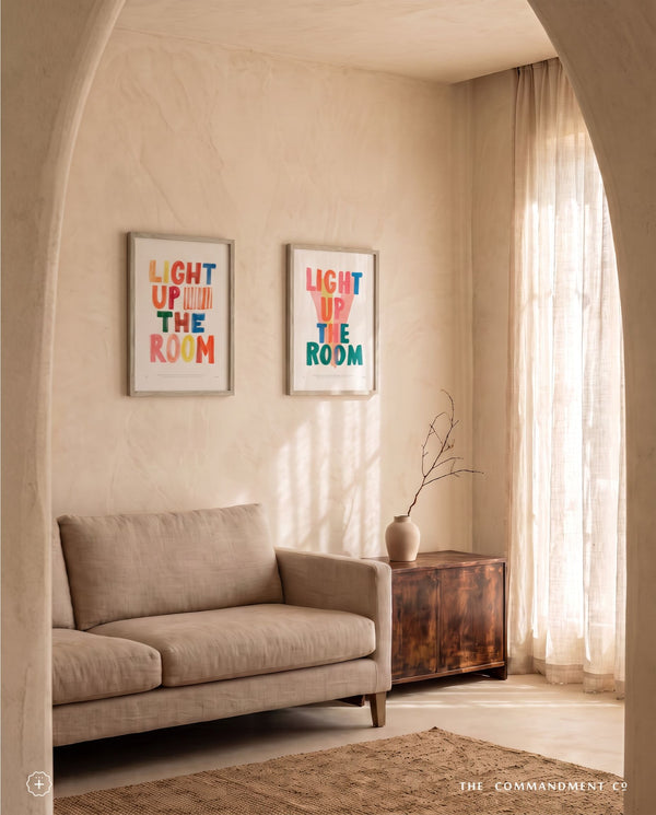 Two Light Up The Room Christian posters displayed in a warm neutral living room with sunlight