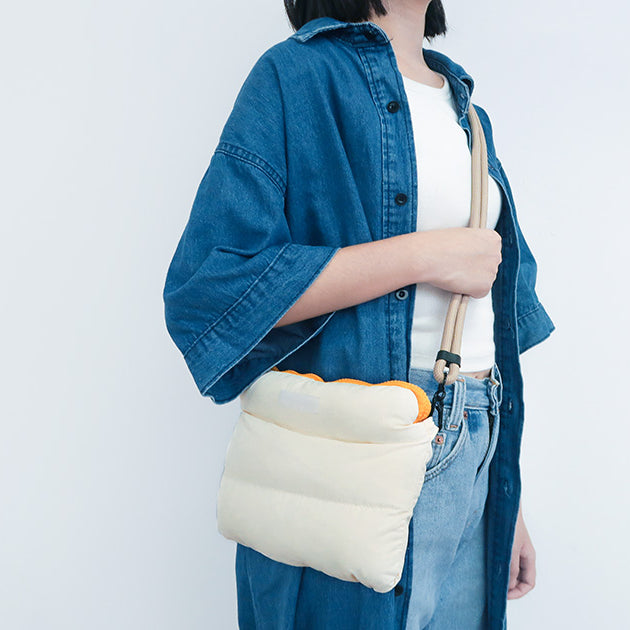 Side view of a person carrying the Oat Pong Pong Bag, displaying its compact, stylish design.