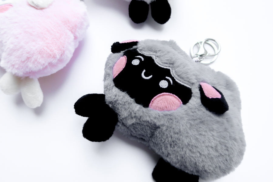 Three faith-inspired Lil Sheepies plush keychains in White Cumulus, Pink Hana, and Stormy Gray are displayed on a white background. Each soft, fluffy sheep represents a reminder of the Good Shepherd’s love, featuring a Bible verse charm, a retractable string for easy card access, and a secure keychain clip. Perfect as a Christian gift or daily faith companion.