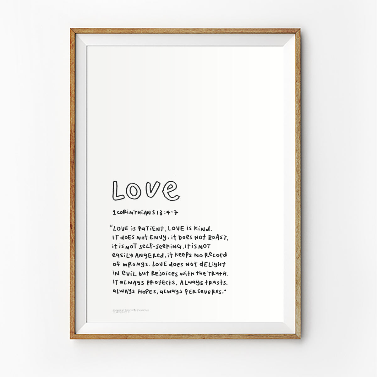 Love Bible verse poster featuring 1 Corinthians 13:4-7 in a simple handwritten style, displayed in a framed wall art mockup.