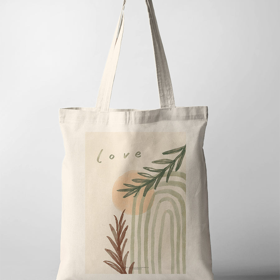 Minimalist Christian tote bag featuring the word “Love” with abstract arches, soft peach tones, and botanical illustrations