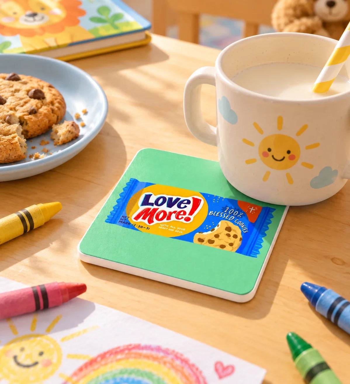 Love More Chocolate Chip Biscuit coaster with white sides on a sunny child's table beside milk and crayons