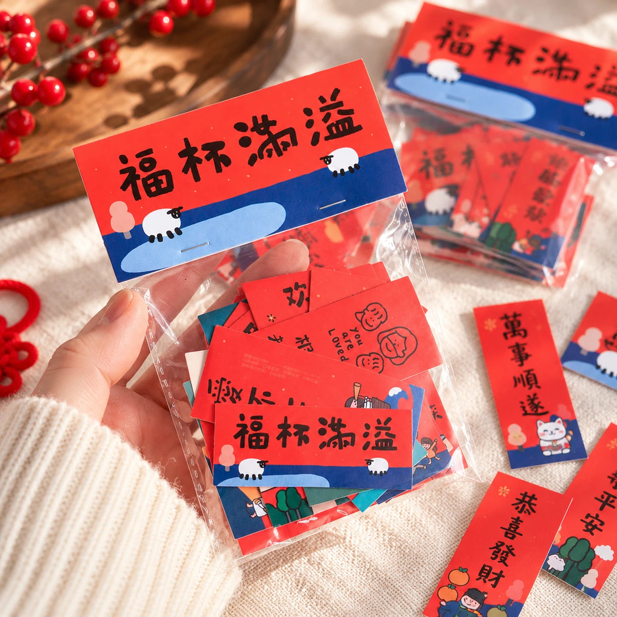 Mini Chinese New Year couplets sticker pack in a hand with festive red blessing stickers around it