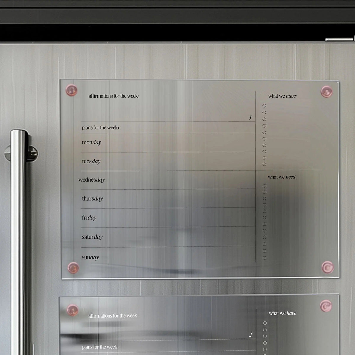 Modern magnetic organizer board for weekly planning, featuring sections for affirmations, daily plans, and checklists for 'what we have' and 'what we need,' mounted on a sleek surface.