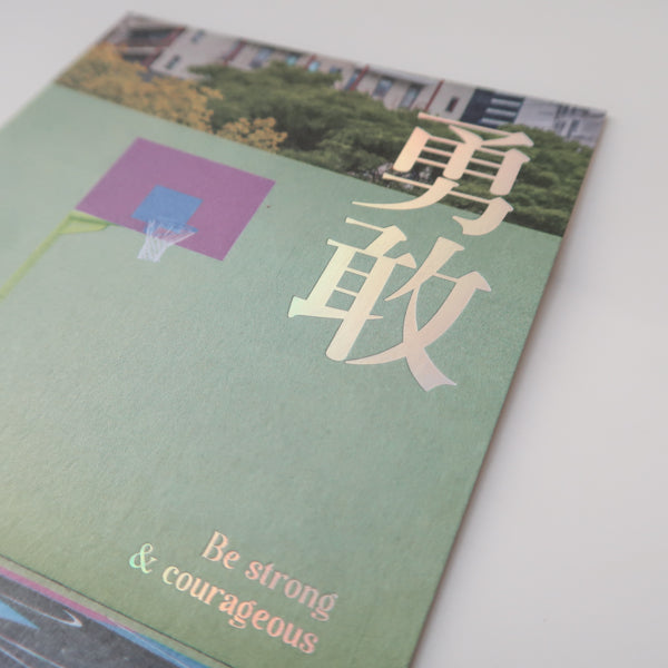A postcard featuring the Chinese characters for "courage" (勇敢) and the inspirational message "Be strong & courageous," set against a colorful basketball court background.
