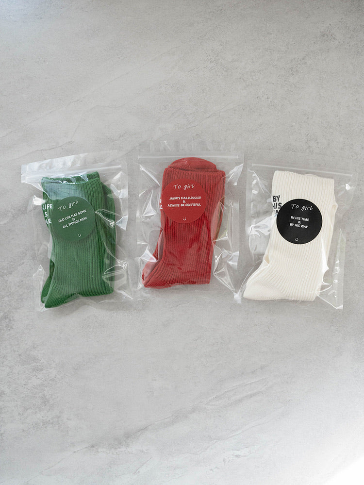 Three ribbed knit socks in green, red, and cream, each in clear packaging with circular labels; features the phrases “Always Hallelujah” and “Always Be Grateful” for a Christian gift and daily faith reminder.