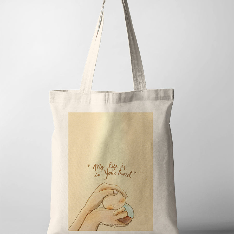 Christian tote bag featuring hands gently holding a small child with the phrase “My life is in Your hand,” inspired by Psalm 31:15