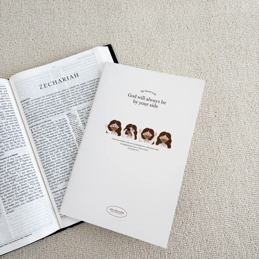 Open notebook "God will always be by your side" placed next to a Bible, showcasing the beautiful design and inspirational message from Jeremiah 31:3.