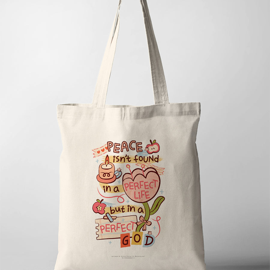 Christian tote bag featuring “Peace isn’t found in a perfect life, but in a perfect God” with colourful floral artwork