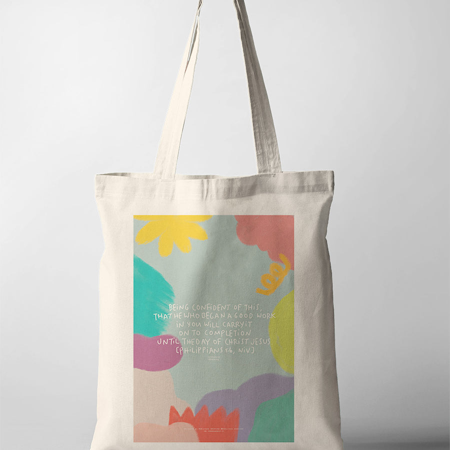 Christian tote bag featuring Philippians 1:6 with colourful artwork about God completing the good work He began