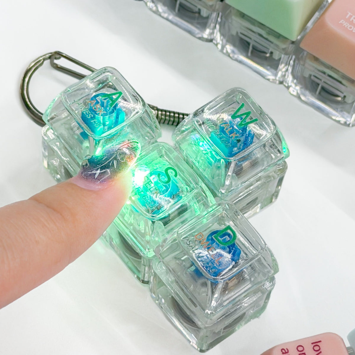 Press-on light-up Christian keycap keychains glowing when pressed, shown together on a bright tabletop
