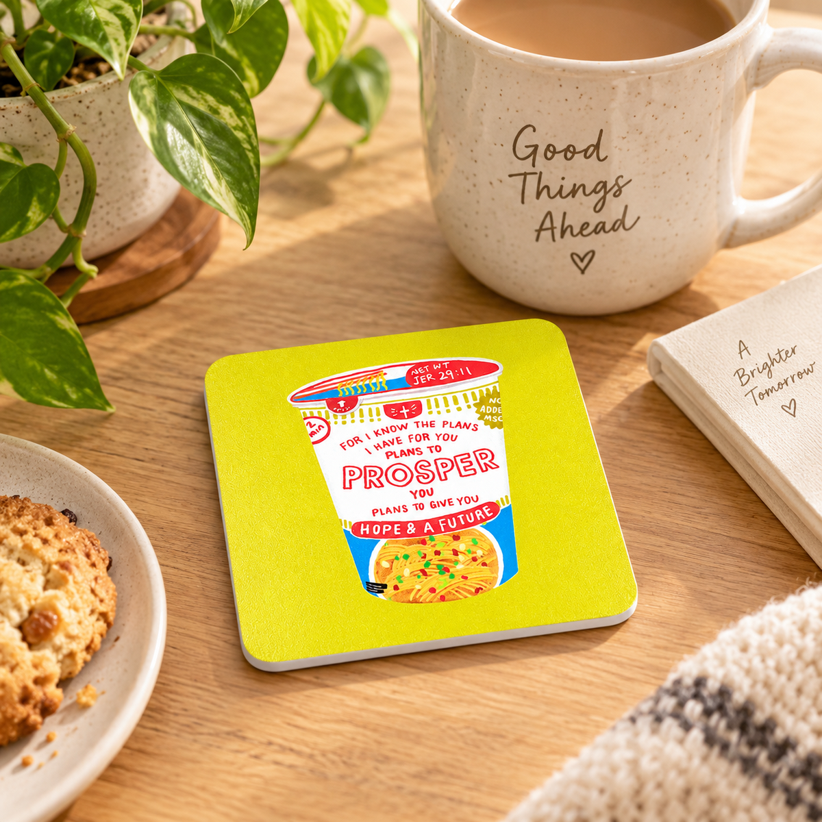 Prosper Cup Noodle Jeremiah 29:11 Christian coaster with white edges on a warm wooden table beside a coffee mug and plant