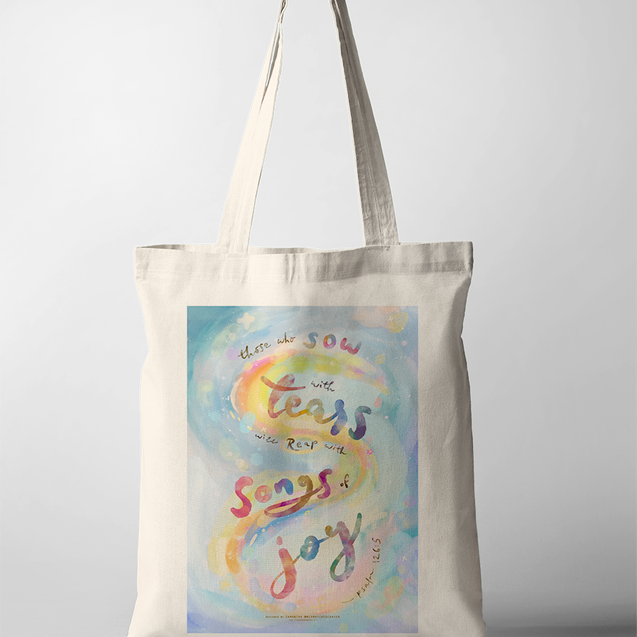 Inspirational Christian tote bag with Psalm 126:5 “Those who plant in tears will harvest with shouts of joy,” watercolor lettering in pastel rainbow tones.