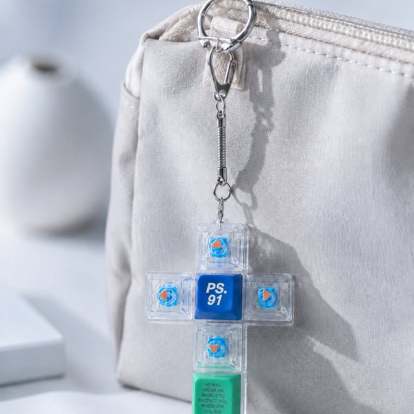 Psalm 91 cross light-up keycap keychain clipped to a beige pouch