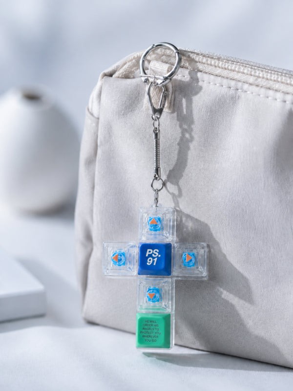 Psalm 91 cross light-up keycap keychain clipped to a beige pouch