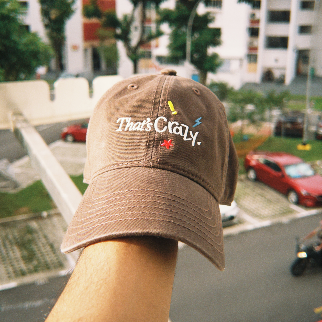 That's Crazy brown embroidered cap by Quite at Home styled for everyday wear.