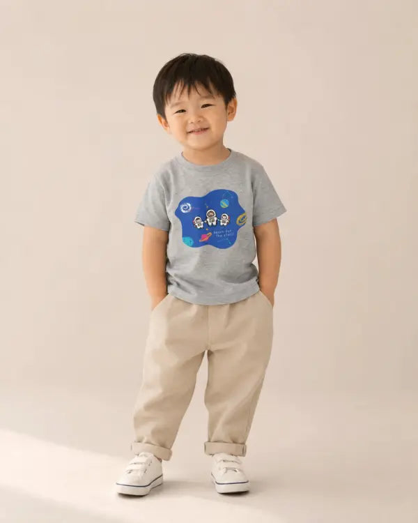 Smiling young boy wearing the grey Reach for the Stars astronaut Jesus kids’ T-shirt
