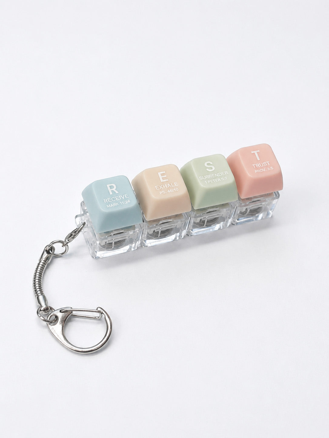REST press-on light-up keycap keychain with pastel coloured keys spelling rest, featuring Scripture-inspired words on a bright white studio background.