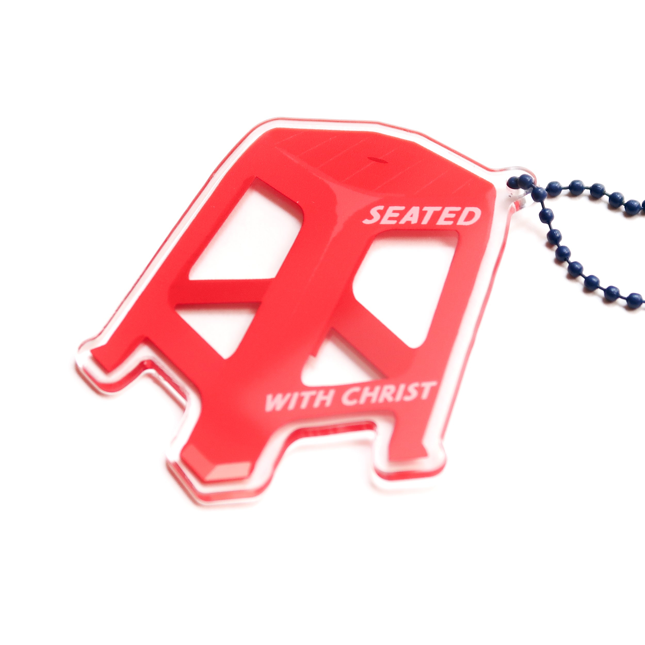 Red chair acrylic keychain with "Seated with Christ" design, from The Commandment Co, Singapore.