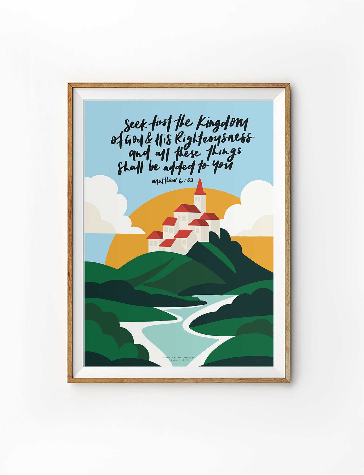 Framed Christian wall art featuring rolling green hills, a peaceful village, and the verse “Seek first the Kingdom of God and His righteousness,” based on Matthew 6:33.