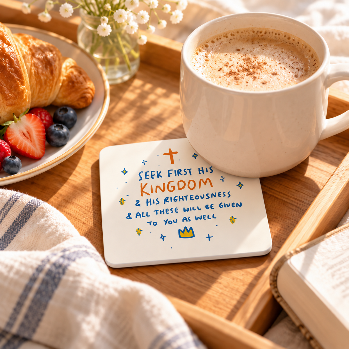 Seek His Kingdom Christian coaster with white sides styled on a breakfast tray beside coffee, croissant and berries in warm morning light