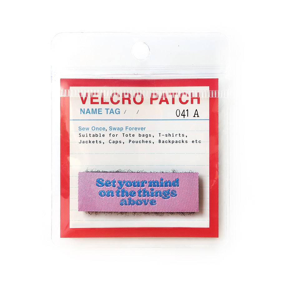 Pink Velcro tag with blue text 'Set your mind on the things above,' an inspirational Christian patch for clothing and accessories
