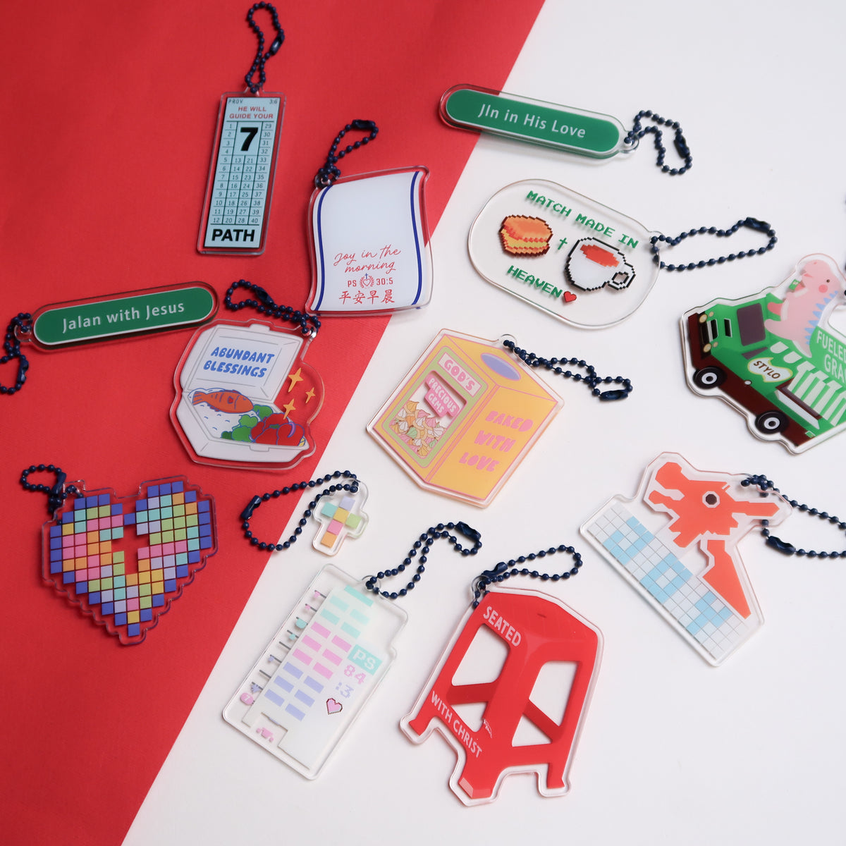Collection of acrylic keychains with Singapore National Day themes, featuring Christian messages and designs, from The Commandment Co.