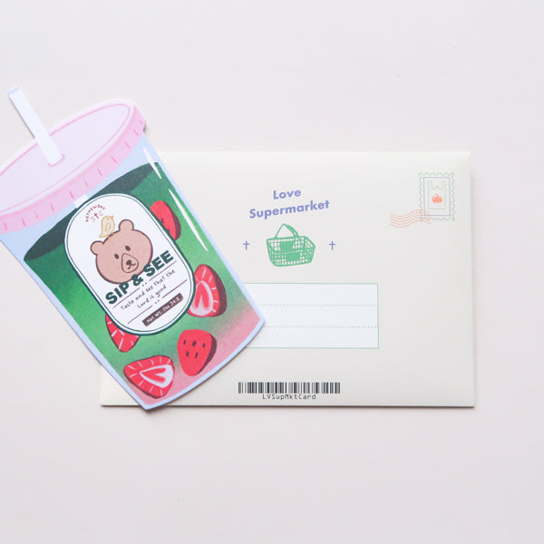 Sip & See matcha drink–shaped Christian postcard displayed with its Love Supermarket envelope.
