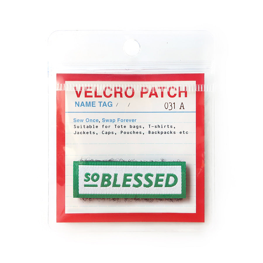 Velcro tag with the phrase 'So Blessed' in green text on a white background with a green border; a Christian-inspired accessory for clothing and bags