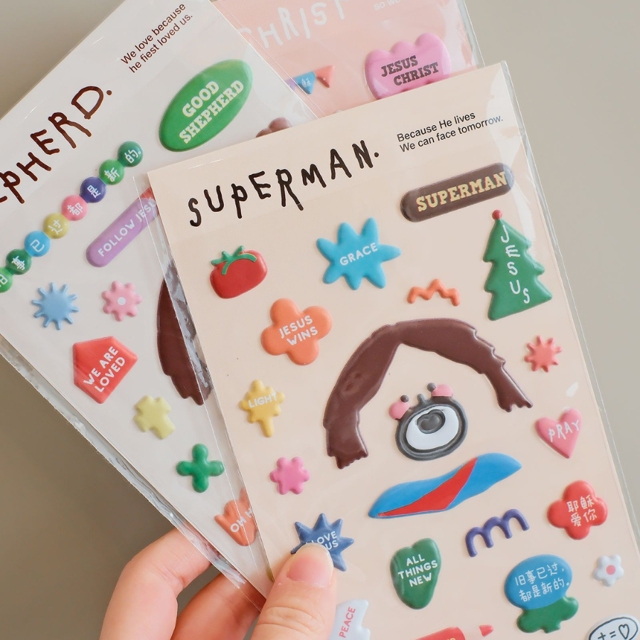 Soft Jesus sticker sheets featuring three designs: Jesus Christ, Superman, and Shepherd, each with colorful and inspirational elements.