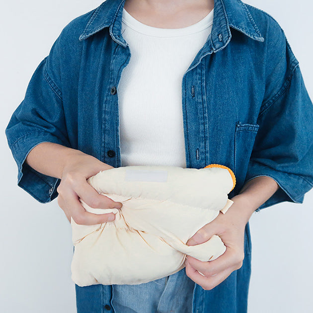 Close-up of the Oat Pong Pong Bag being squeezed to show its soft, cushioned texture.