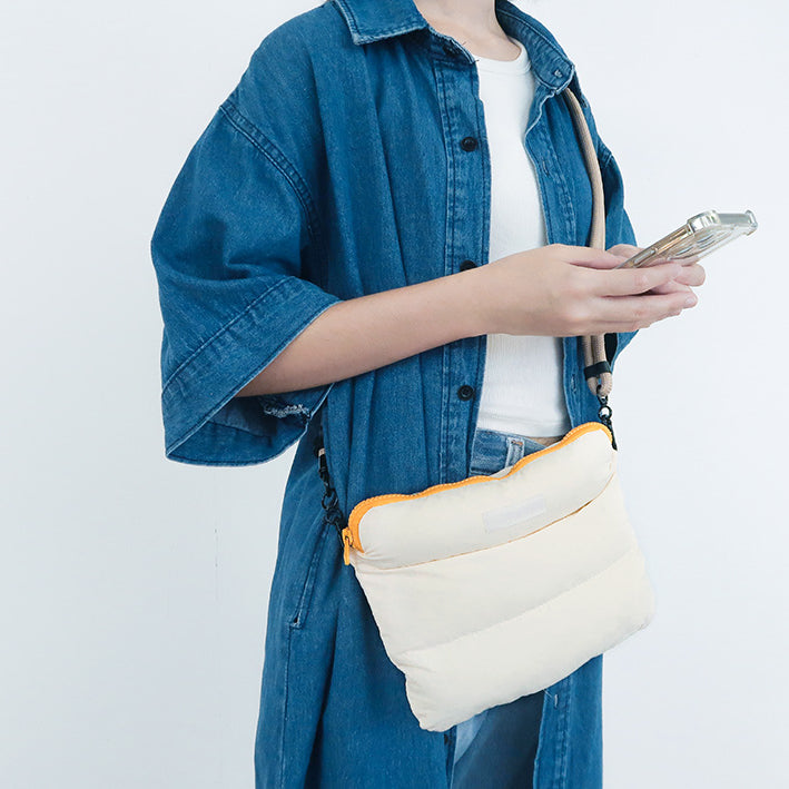 Person carrying the Oat Pong Pong Bag with a comfortable grip, showing its soft, compact design.