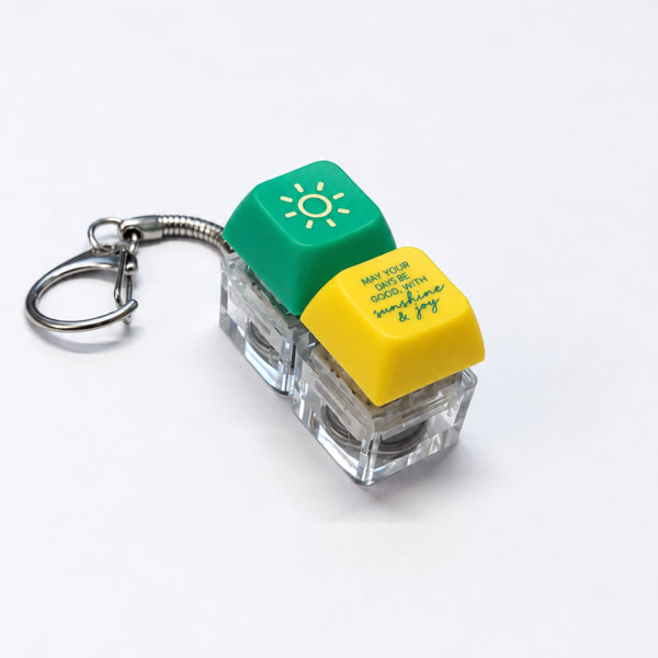 Sunshine and Joy light-up keycap keychain in green and yellow on a white background