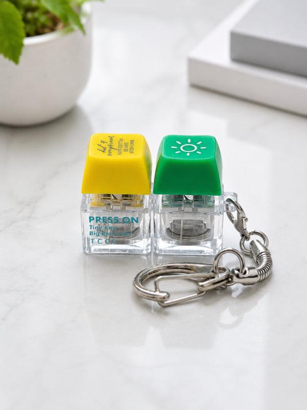 Close-up of the green sun and yellow Sunshine and Joy keycaps with silver keyring