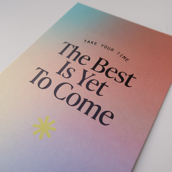 A detailed view of a postcard with a gradient background and the encouraging message "The Best Is Yet To Come," along with the phrase "Take Your Time," designed to inspire hope and positivity.