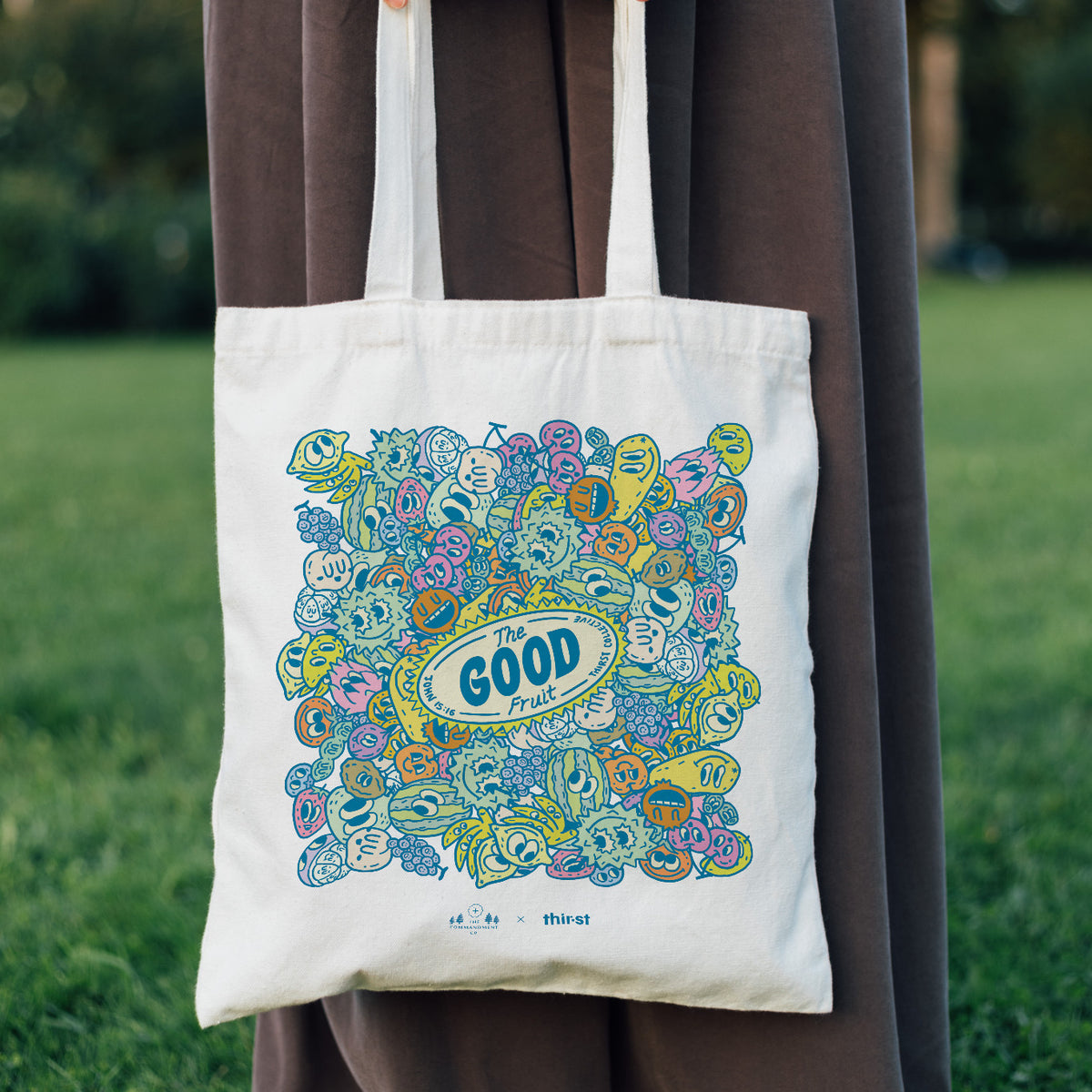 Person carrying The Good Fruit coloured tote bag outdoors