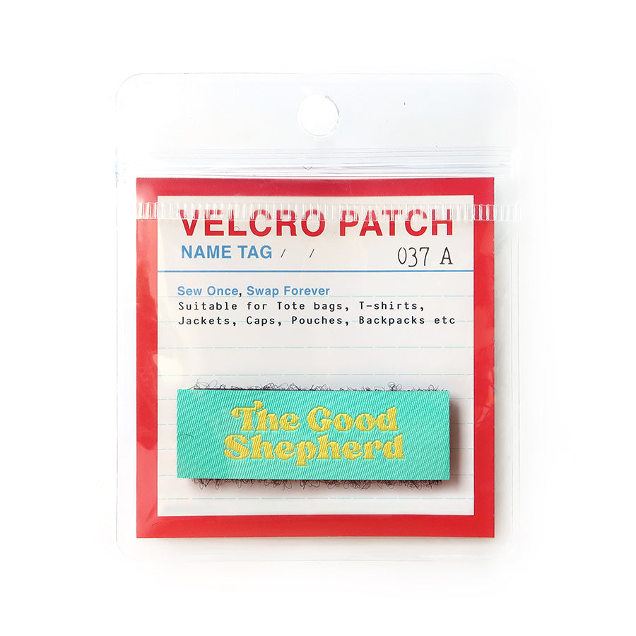 Velcro tag with 'The Good Shepherd' text in yellow on a mint green background, designed as a Christian faith-inspired accessory for bags and clothing