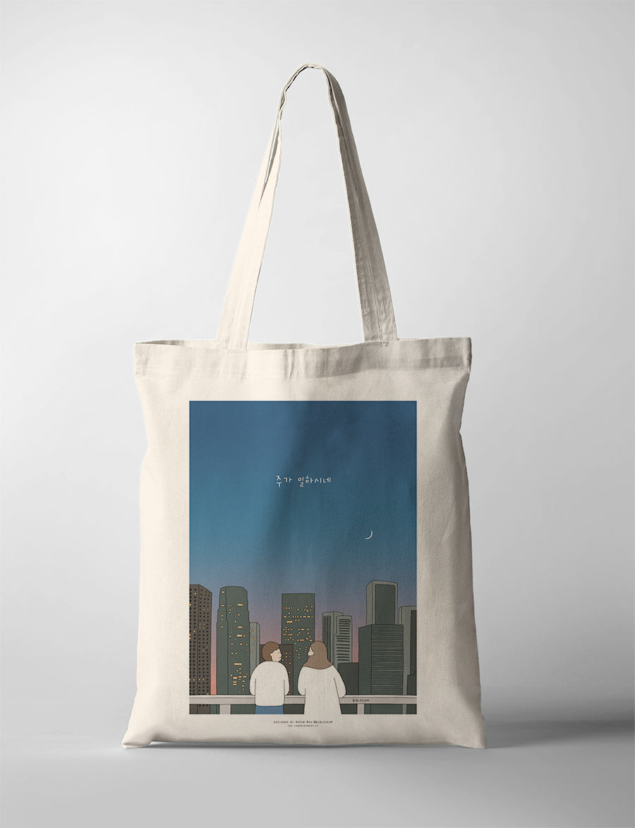 Christian tote bag with Korean phrase “The Lord is Working,” city skyline illustration, and faith message.